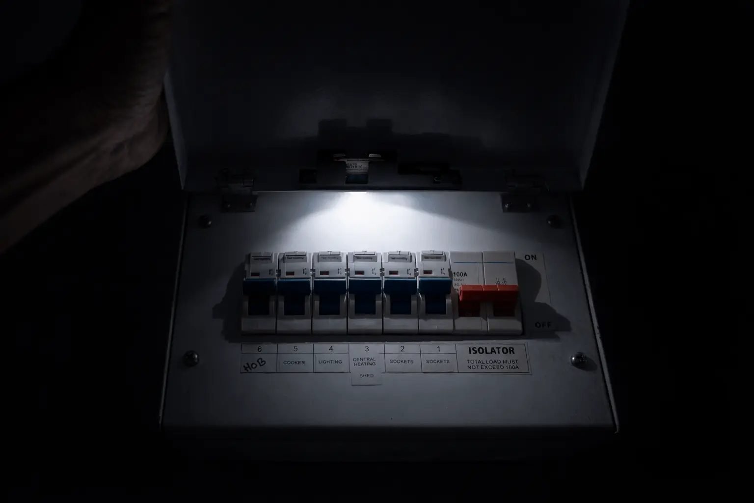 Electrician fault-finding at a fuse box in a Brighton home